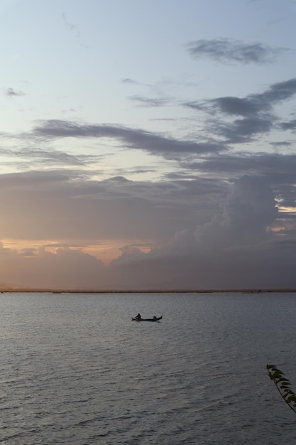 Pêcheur sur son bateau au coucher du soleil. Bateau de pêcheurs au coucher du soleil