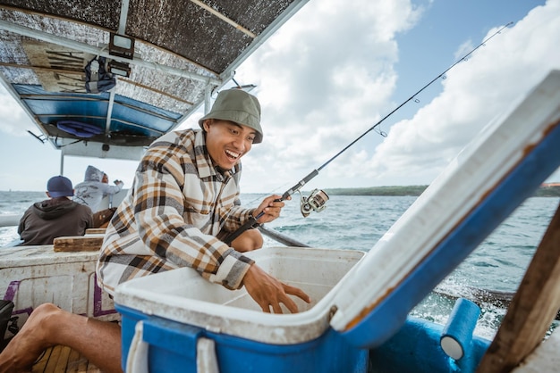 Pêcheur surpris en asie voyant des appâts dans une boîte pendant la pêche