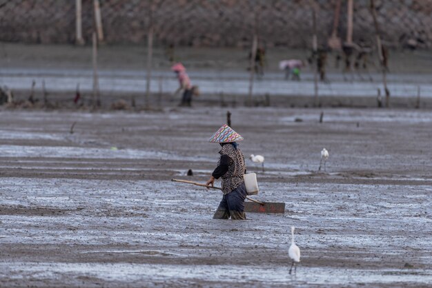 Un pêcheur travaillant sur la plage noire