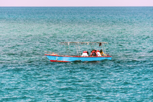 Les pêcheurs sur un bateau jaune naviguent dans la mer