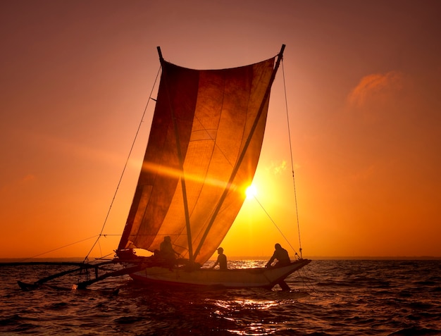 Photo pêcheurs sur un catamaran au coucher du soleil. sri lanka