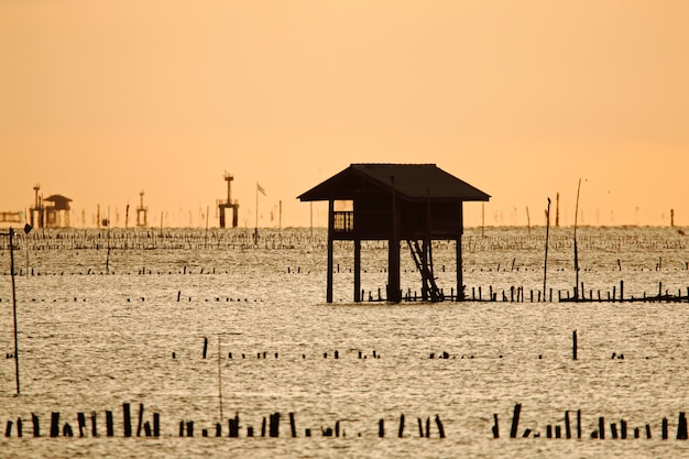 Pêcheurs de maisons en bois au lever du soleil dans la mer