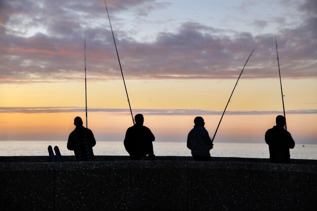 Pêcheurs pêchant à un coucher de soleil à la vanille sur l'océan Atlantique