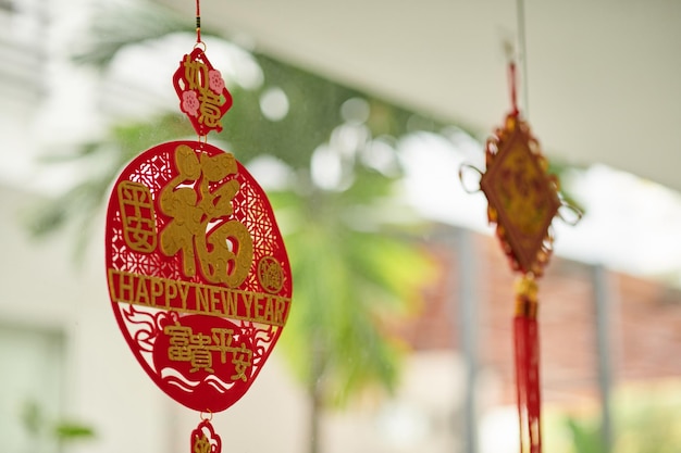 Des pédants rouges et or accrochés au porche de la maison pour attirer la chance et la prospérité au nouvel an