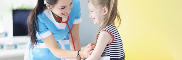 Pédiatre écoutant les poumons et le coeur de la petite fille en clinique