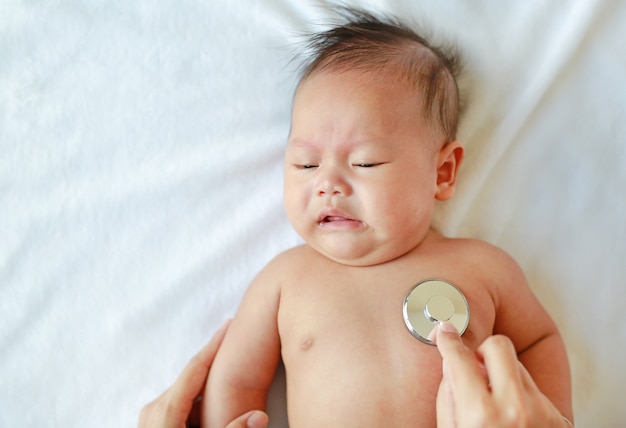 Pédiatre examinant bébé avec un stéthoscope.