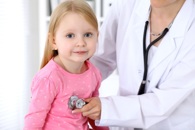 Un pédiatre prend soin d'un bébé à l'hôpital Une petite fille est examinée par un médecin au stéthoscope Concept d'assurance-maladie et d'aide