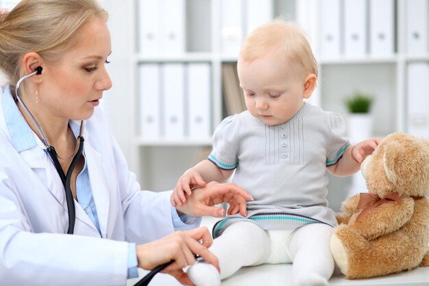 Un pédiatre prend soin de bébé à l'hôpital Une petite fille est examinée par un médecin avec un stéthoscope Assurance soins de santé et concept d'aide