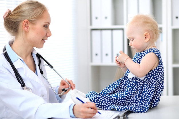 Le pédiatre prend soin de bébé à l'hôpital. Une petite fille est examinée par un médecin avec un stéthoscope. Concept de soins de santé, d'assurance et d'aide.