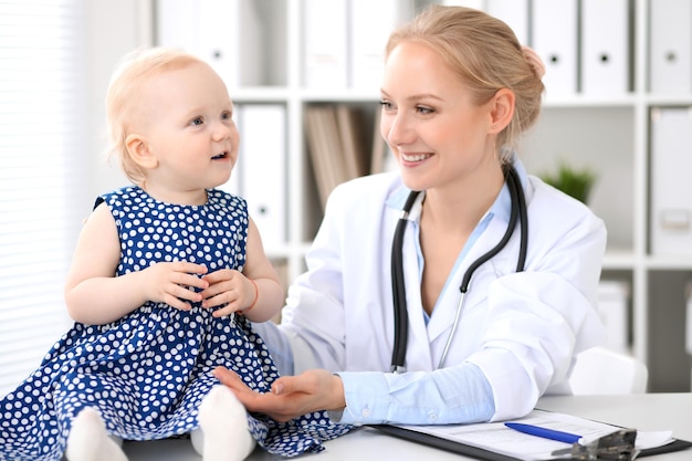 Le pédiatre prend soin de bébé à l'hôpital. Une petite fille est examinée par un médecin avec un stéthoscope. Concept de soins de santé, d'assurance et d'aide.