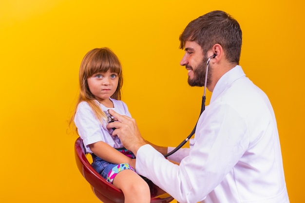 Pédiatrie et concept de contrôle régulier. Médecin caucasien attentif et agréable vérifiant le rythme cardiaque et la respiration du petit enfant à l'aide d'un stéthoscope.