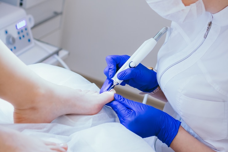 Photo pédicure de matériel professionnel utilisant un client d'appareil électrique sur une procédure de pédicure médicale