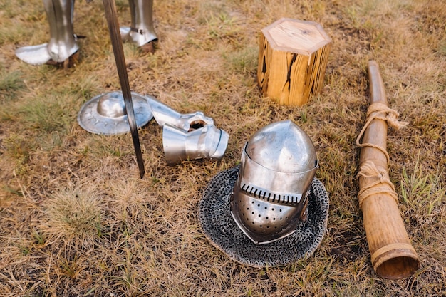 Épée de casque de chevalier et corne de bataille au sol