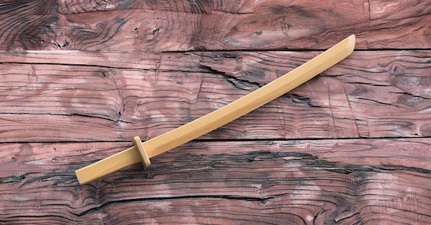 Épée katana en bois sur fond de bois