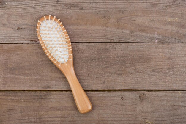 Peigne brosse à cheveux en bois pour les cheveux sur fond de bois brun