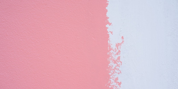 Peignez un apprêt blanc et appliquez du rose sur le mur de ciment. Fond de texture de mur de ciment blanc et rose.