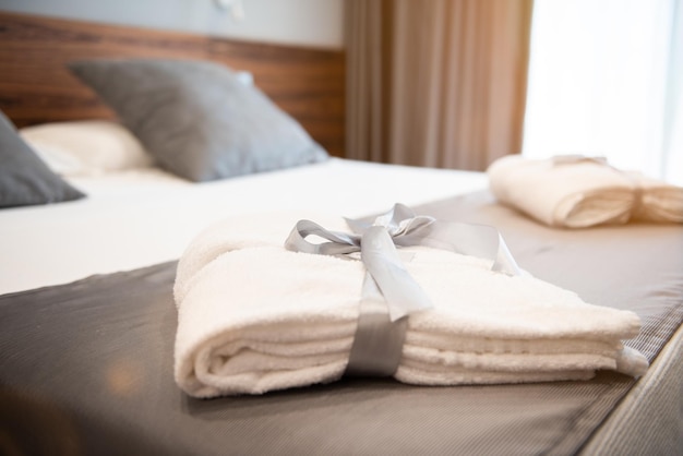 Un peignoir blanc sur le lit de la chambre d'hôtel en gros planxDxA