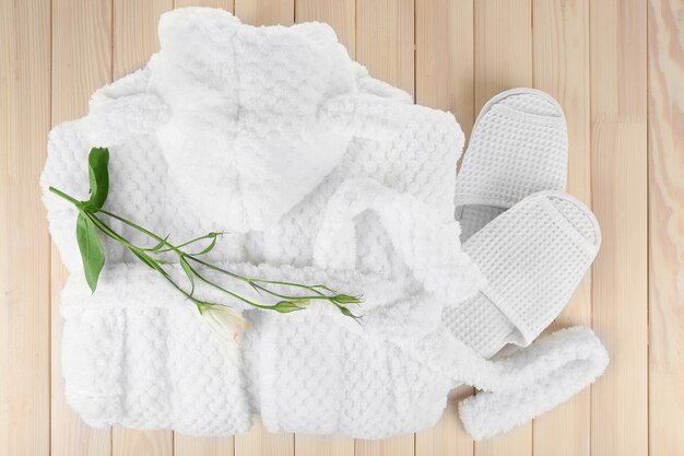 Peignoir et chaussons sur table en bois, vue du dessus