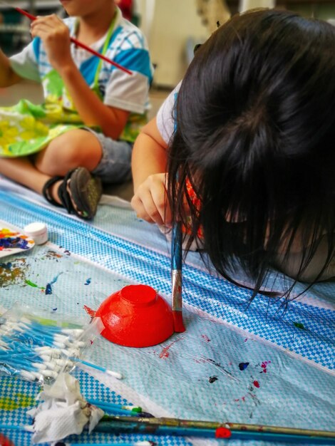 Photo peindre le bol d'argile par un enfant enfant apprenant à peindre dessin concept d'art