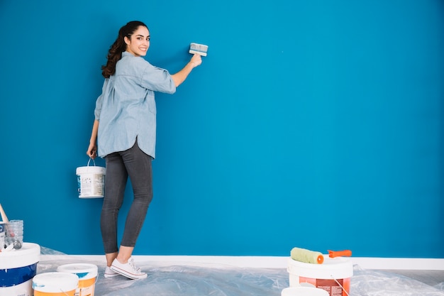 Peindre le concept avec la femme peinture mur bleu