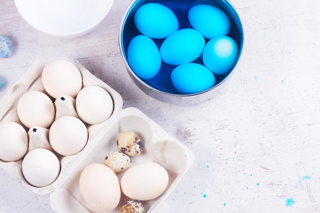 Peindre des oeufs pour pâques dans une scène de vue de dessus bleue