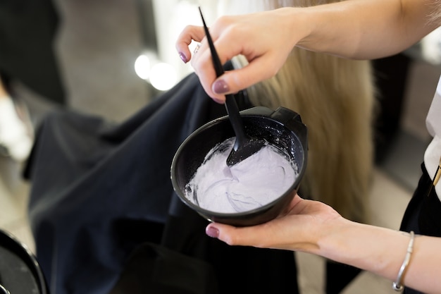 Peindre avec un pinceau entre les mains d'un coiffeur