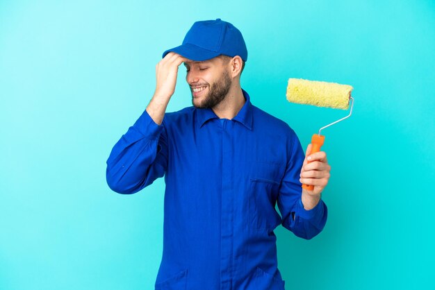 Peintre caucasien homme isolé sur fond bleu a réalisé quelque chose et a l'intention de trouver la solution