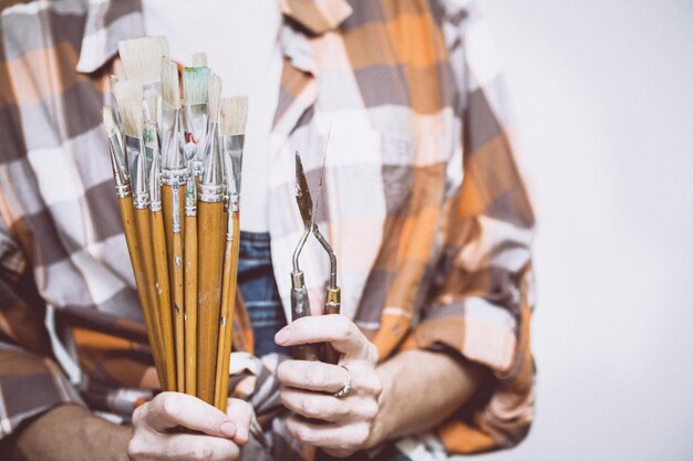 Le peintre de fille tient une brosse