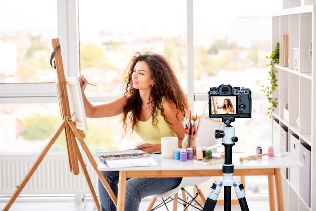 Peintre De Jolie Fille Faisant Une Nouvelle Photo Assise En Atelier