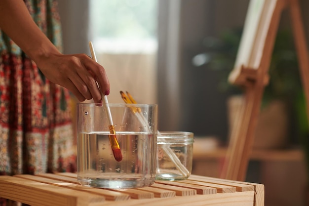 Peintre mettant le pinceau dans l'eau