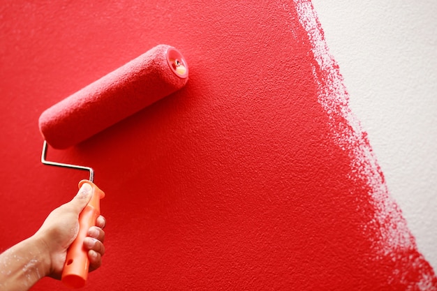 Photo le peintre peint le mur intérieur en rouge