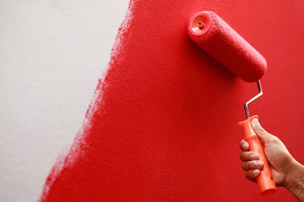 Le peintre peint le mur intérieur en rouge