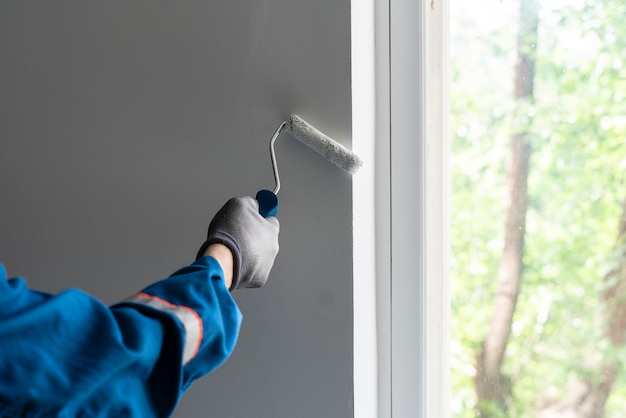 Un peintre professionnel faisant son travail tenant un rouleau à peinture