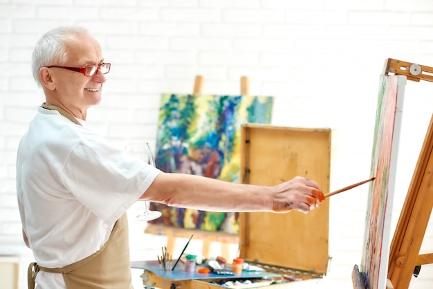 Photo un peintre talentueux dessine une image dans un studio d'art à l'aide de peinture et d'un pinceau.