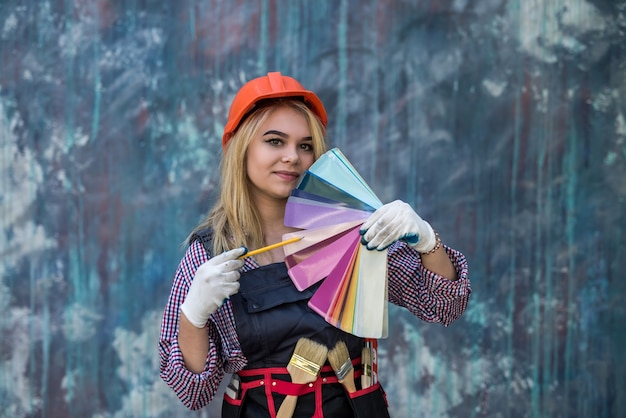 Peintre en uniforme et casque avec tableaux de peinture