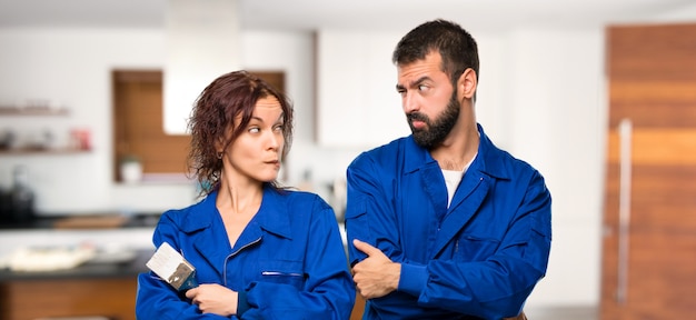 Les peintres ayant des doutes et une expression de visage confuse tandis que les lèvres mordent dans la maison