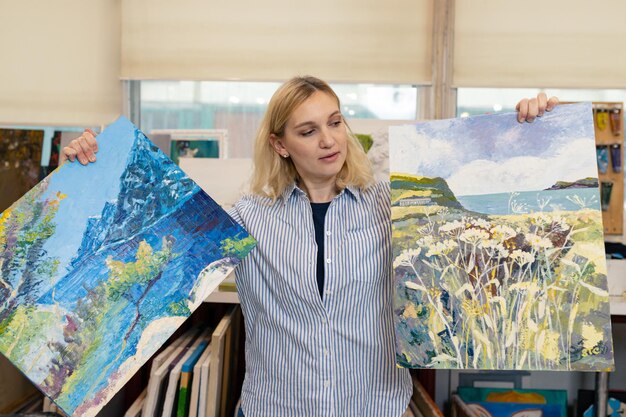 Peinture d'art une artiste féminine tient ses peintures dans ses mains