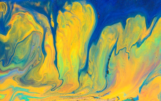 La peinture bleue coule vers la texture des encres mélangées jaunes