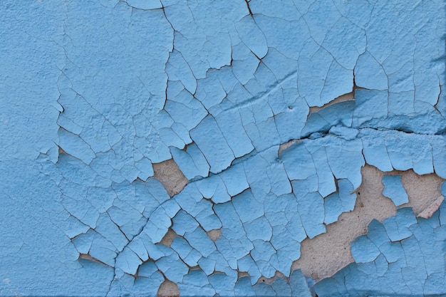 Peinture bleue craquelée sur un vieux mur de ciment L'ancien fond est peint en bleu sur les murs