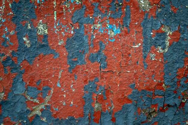 Peinture bleue et rouge sur le vieux mur de béton. Mur patiné avec peinture écaillée.