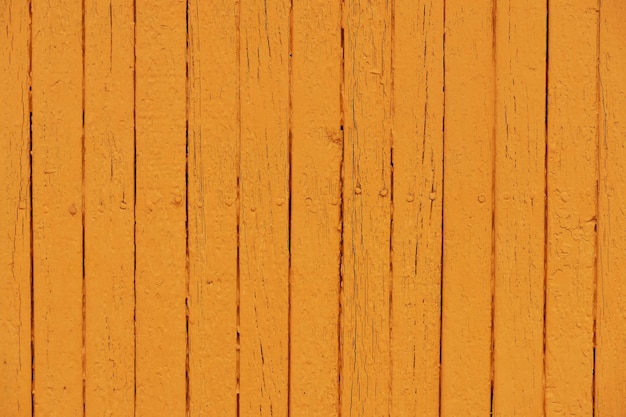 Peinture feuilletée orange sur une clôture en bois