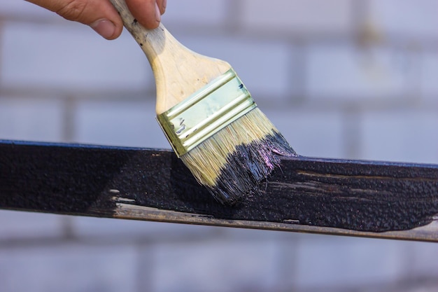 Peinture de fille avec un pinceau métal noir peint le toit