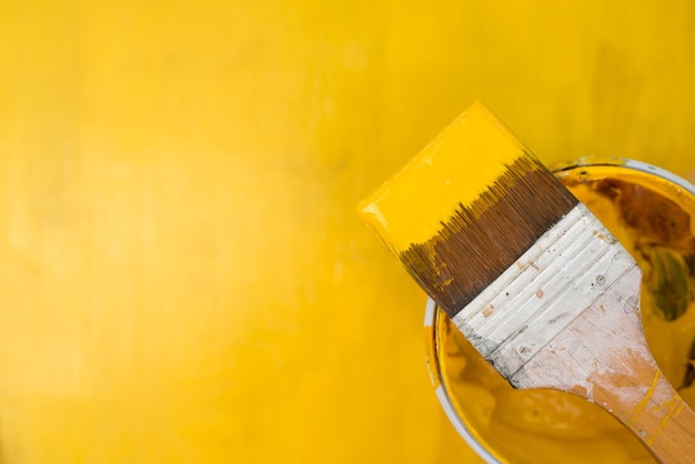 Peinture jaune éclaboussant de la brosse.