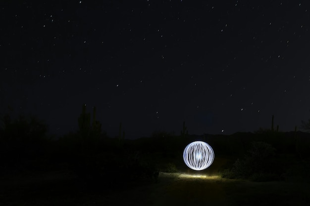 Peinture lumineuse sur le champ contre le ciel la nuit