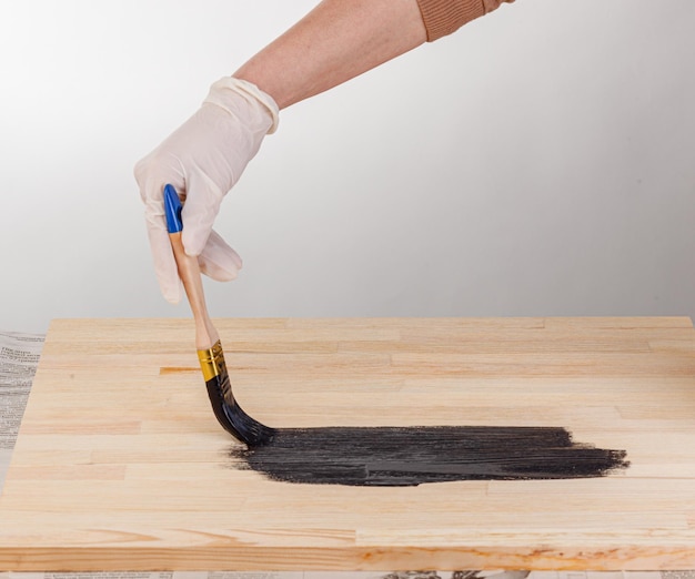 Peinture à la main de fond en bois avec pinceau et pot de peinture