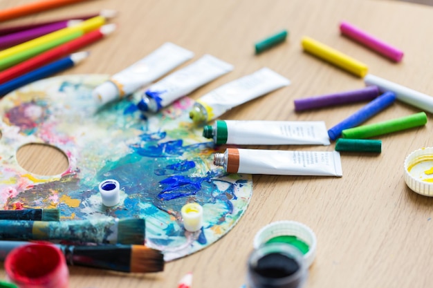 Photo peinture et outils artistiques concept de gros plan de couleur acrylique ou de tubes de peinture avec des crayons et une palette