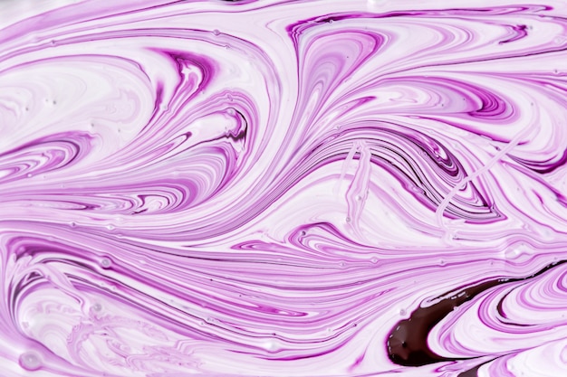 Photo peinture violette et blanche mélangée créant un beau motif abstrait.