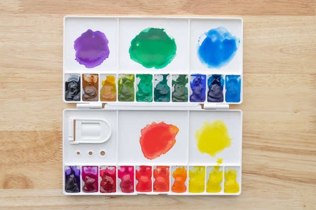 Peintures aquarelles colorées dans une palette aquarelle sur bois. Peintures aquarelles multicolores lumineuses dans une boîte de peinture.