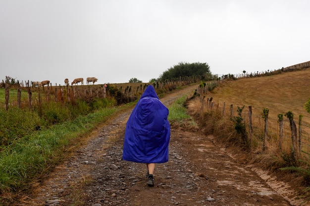 Pèlerin marchant sur la route de campagne à jour de pluie pendant le Chemin du Puy France