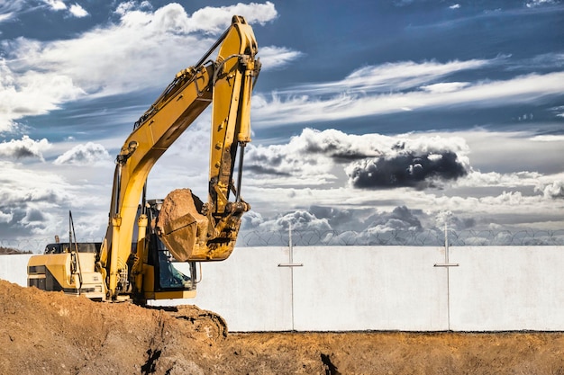 Pelle sur chenilles jaune sur le chantier Travaux de terrassement sur un chantier de construction Matériel de terrassement moderne